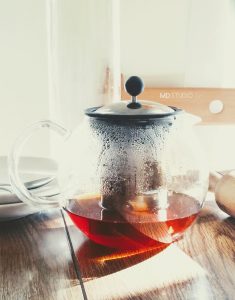 lumière se reflétant sur le thé et à travers le verre d'une théière